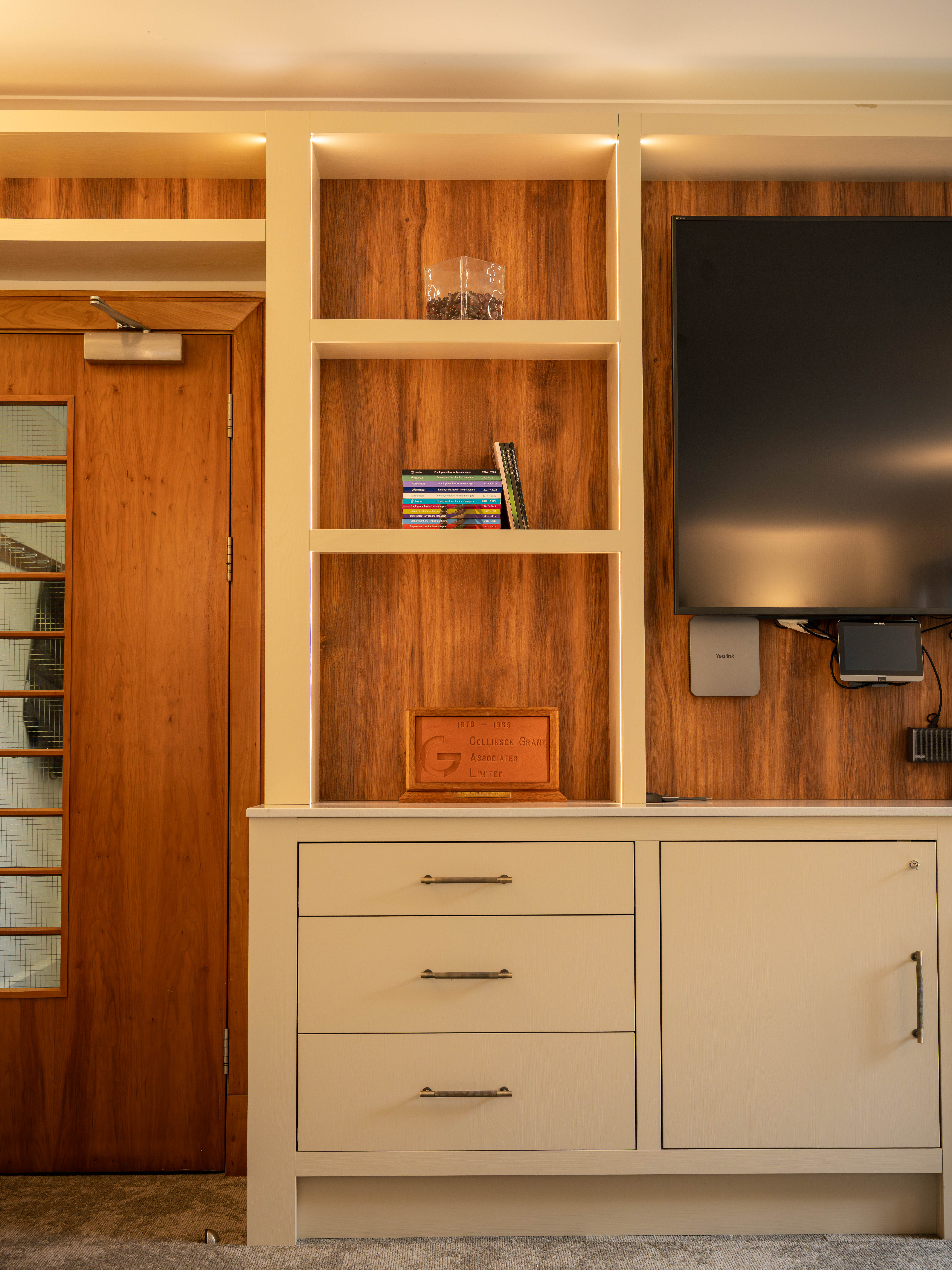 Collinson Grant boardroom shelving unit with publications and founding plaque — Hafferty Interiors Worsley