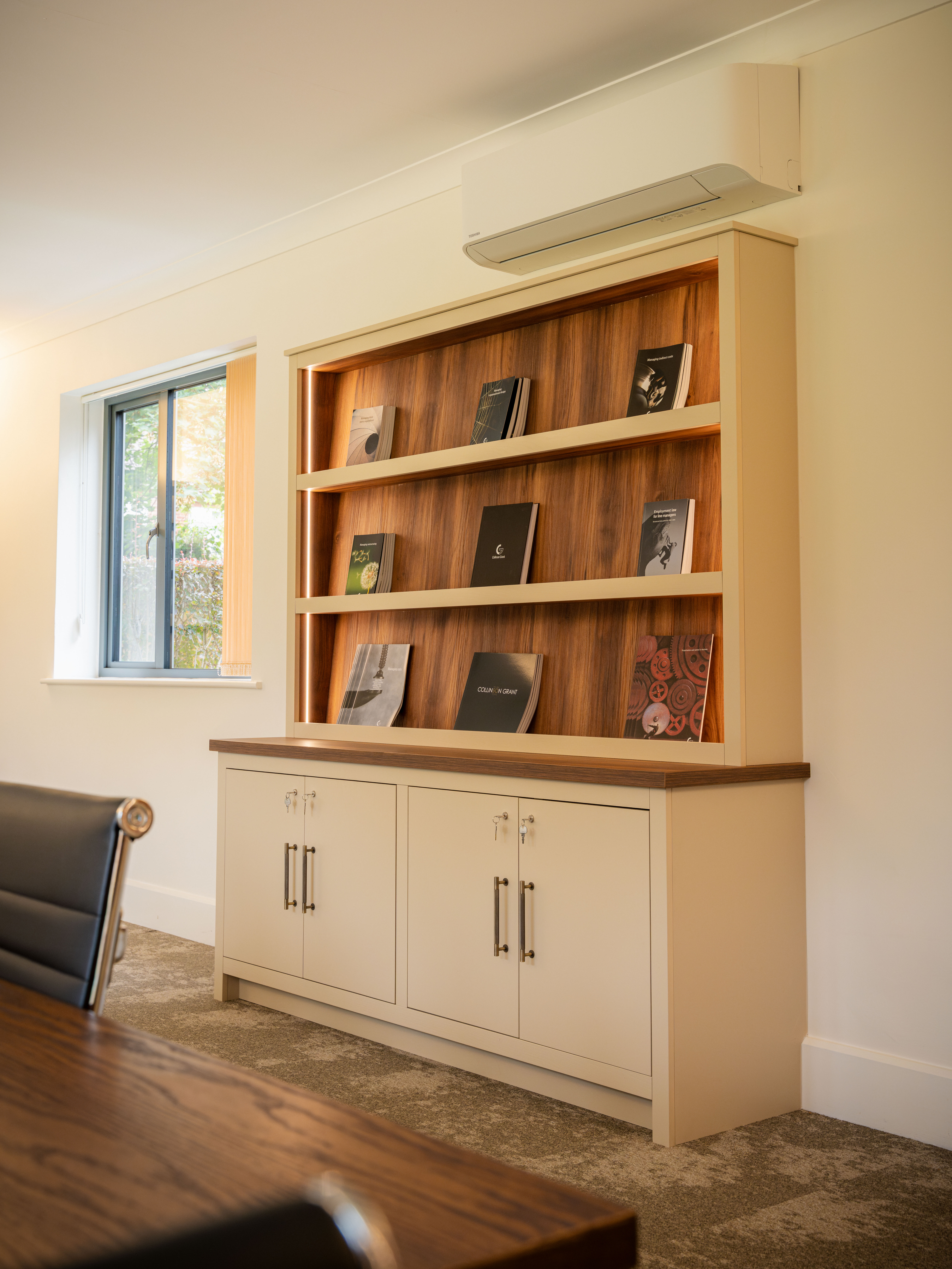 Cohesive cream painted joinery with walnut backing — Collinson Grant boardroom by Hafferty Interiors