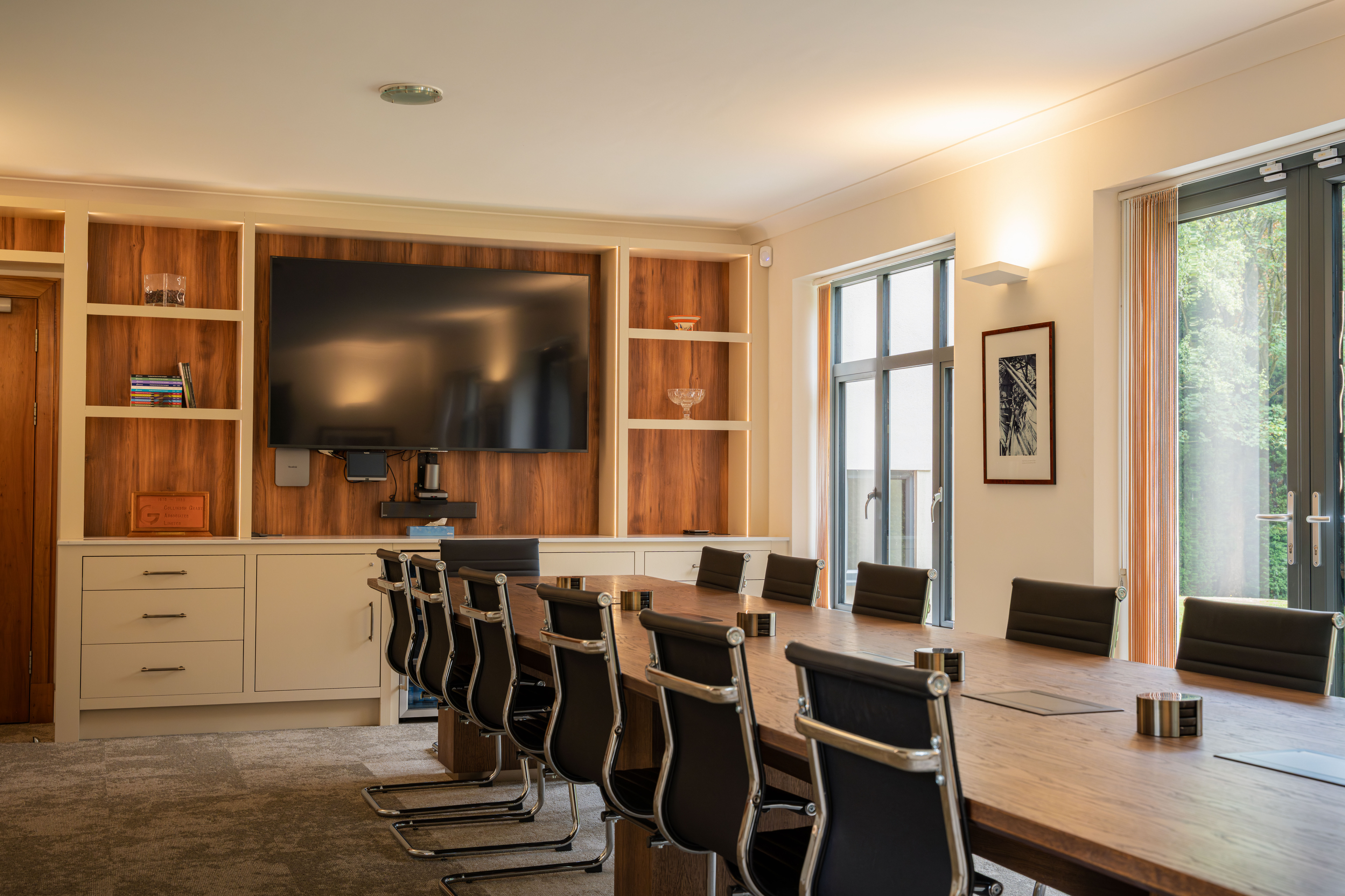 Bespoke boardroom with integrated screen and oak conference table — Collinson Grant Worsley by Hafferty Interiors