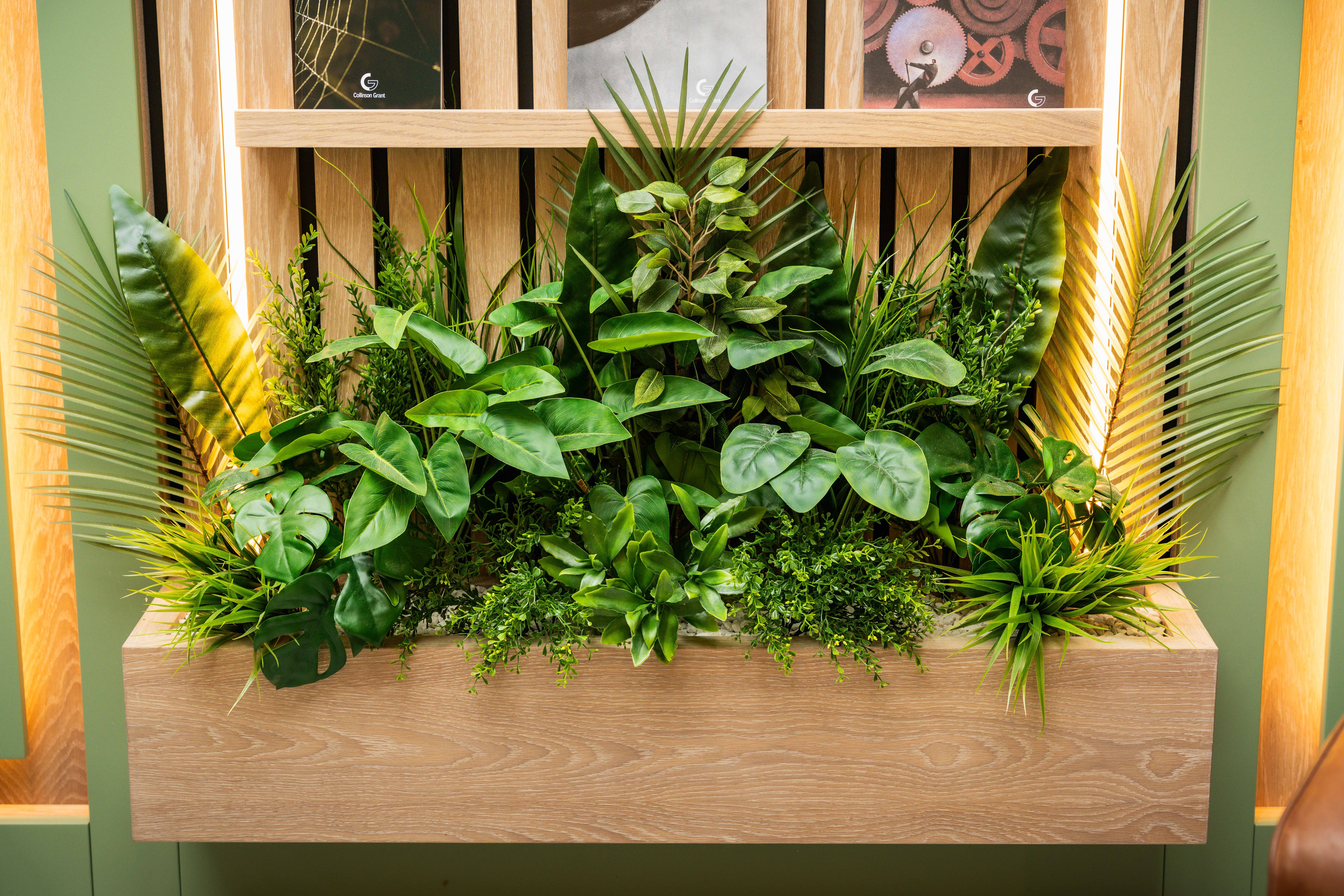 Natural oak vertical slat feature wall with integrated display shelving — Collinson Grant by Hafferty Interiors