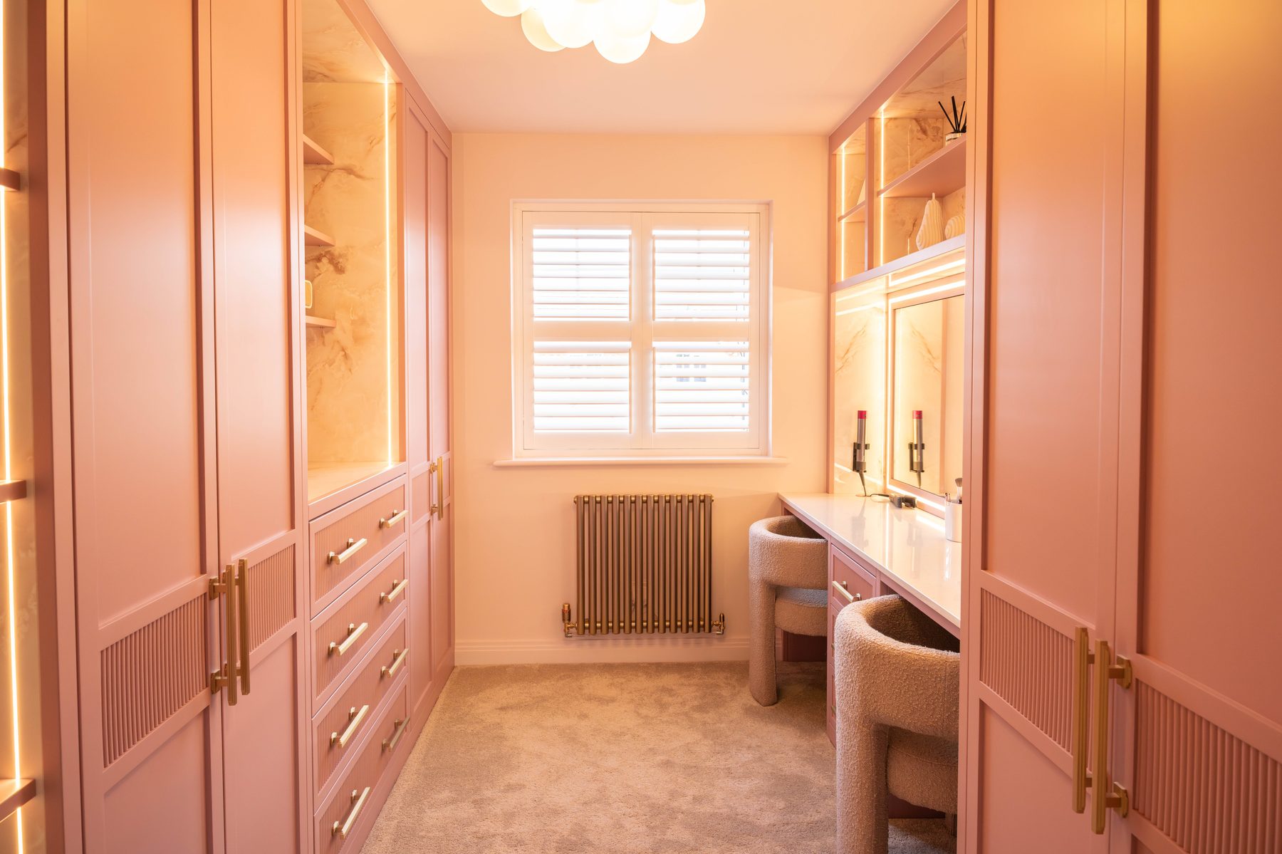 Symmetrical storage in pink bespoke dressing room — Hafferty Interiors Manchester