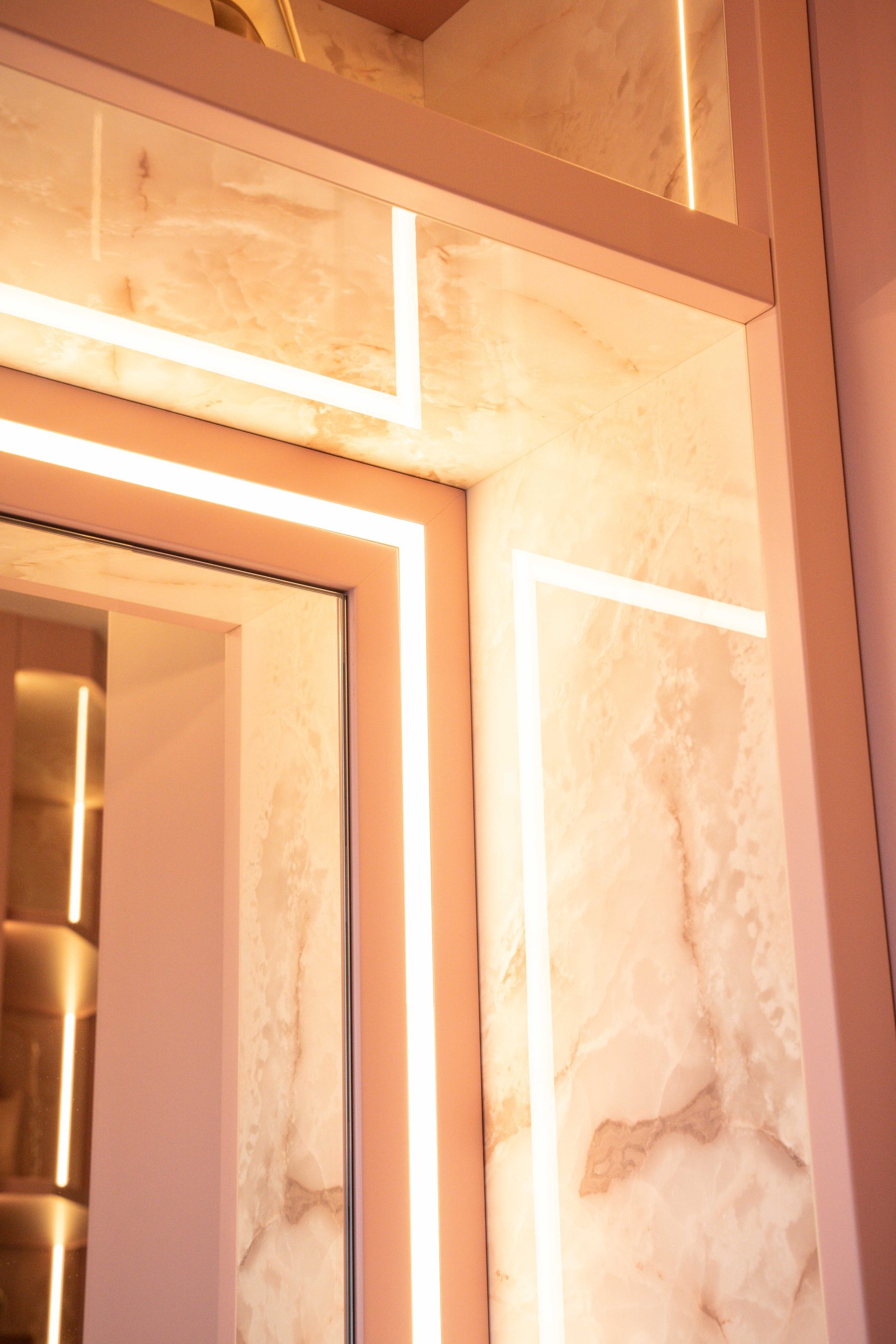 Pink bespoke dressing room with reeded inlay and brass hardware — Evans commission by Hafferty Interiors