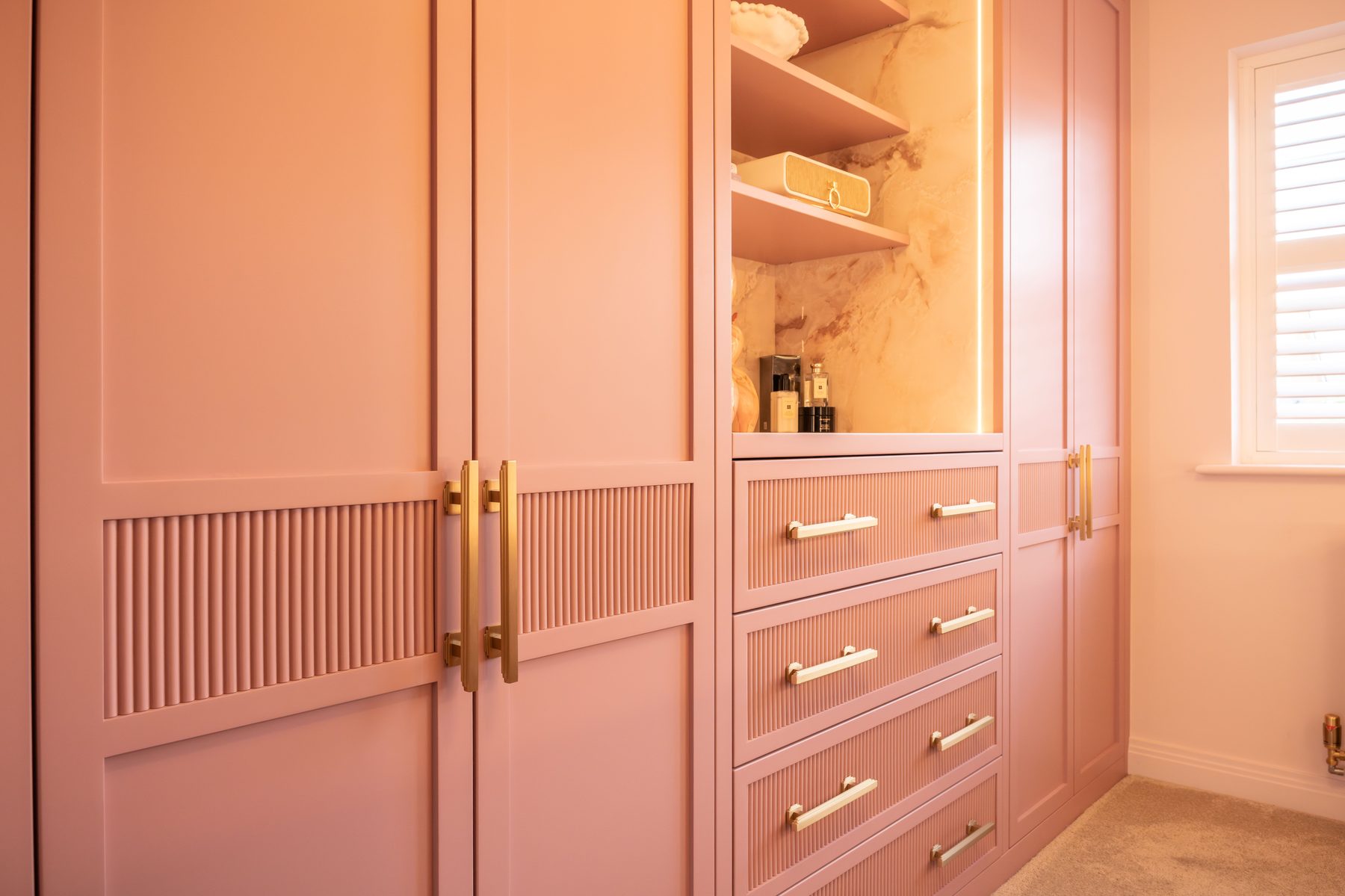 Pink brass reeded inlay door detail — bespoke dressing room by Hafferty Interiors Manchester