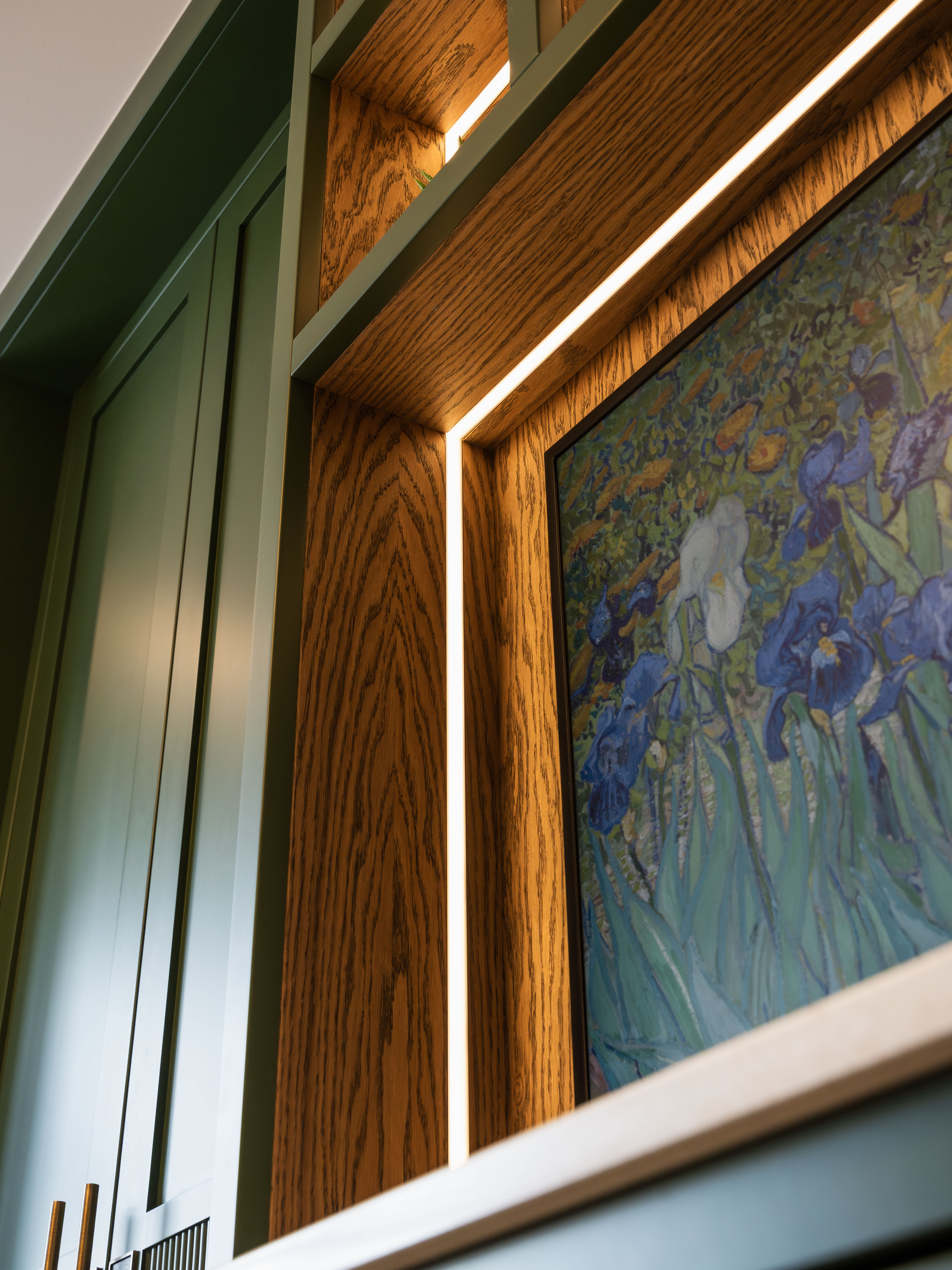 Seamless LED lighting and artwork framed in bespoke Farrow and Ball green joinery — Hafferty Interiors Manchester