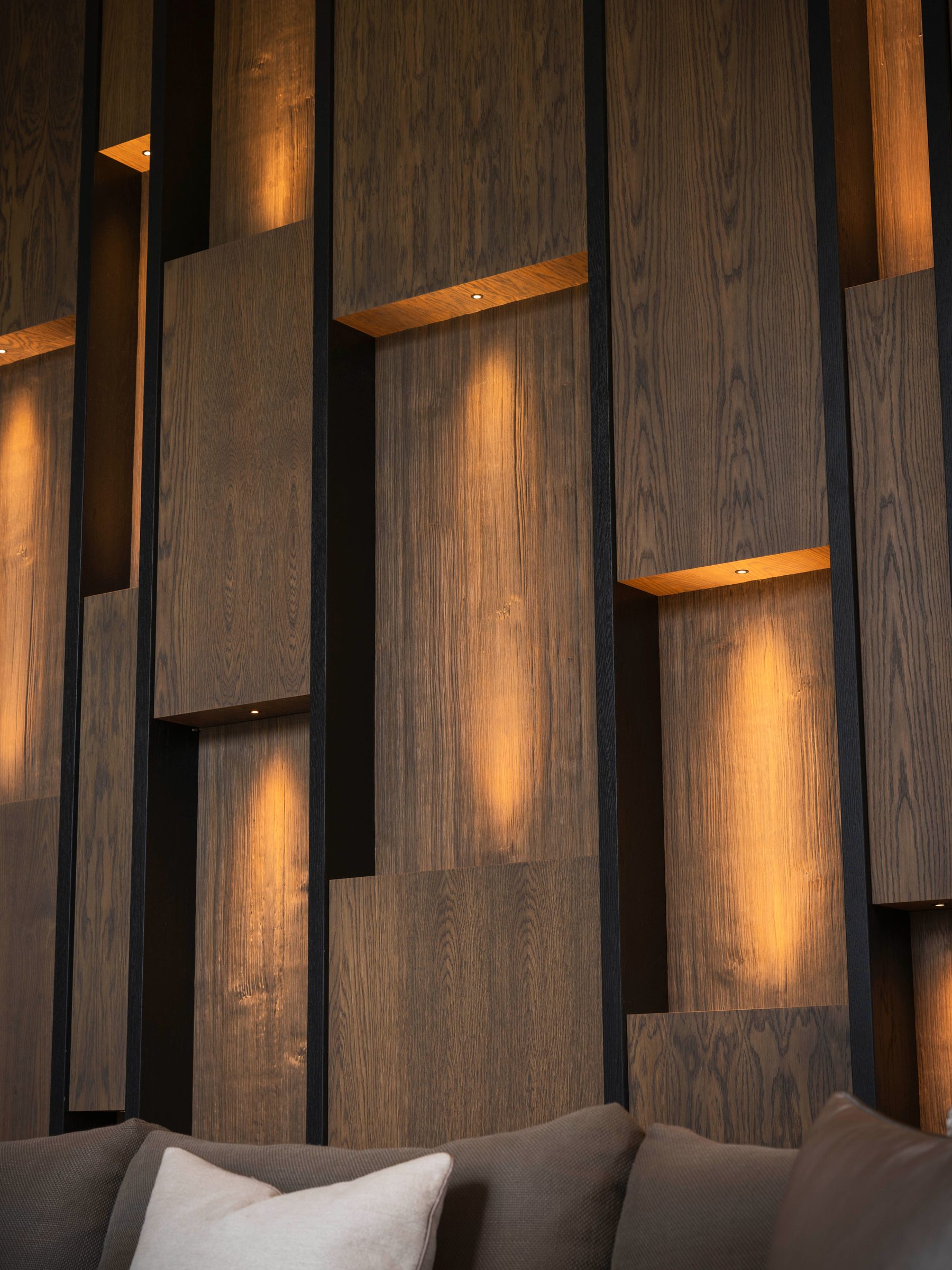 Bespoke staggered oak slat wall with individually recessed spotlights — Hafferty Interiors luxury living room
