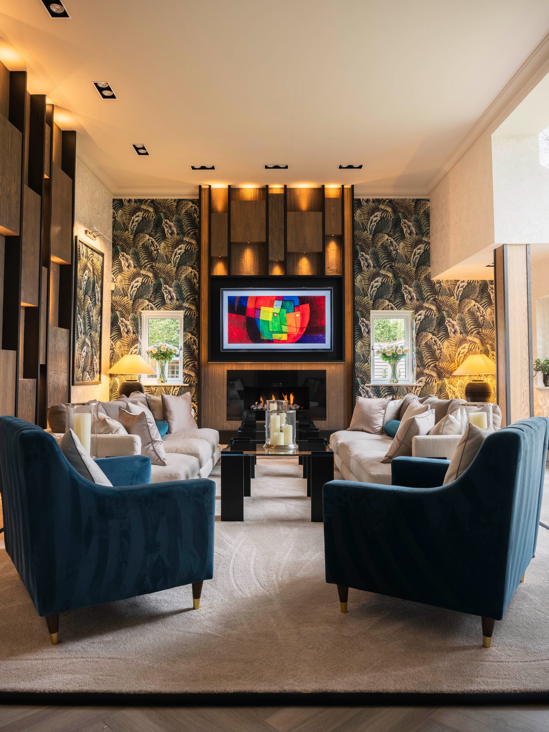 Luxury bespoke living room viewed through entrance — oak media wall, botanical wallpaper and teal velvet armchairs — Hafferty Interiors