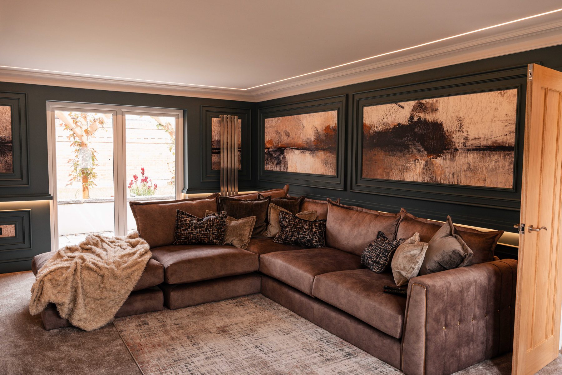 Bespoke panelled living room with large corner sofa and garden doors — Boothstown by Hafferty Interiors
