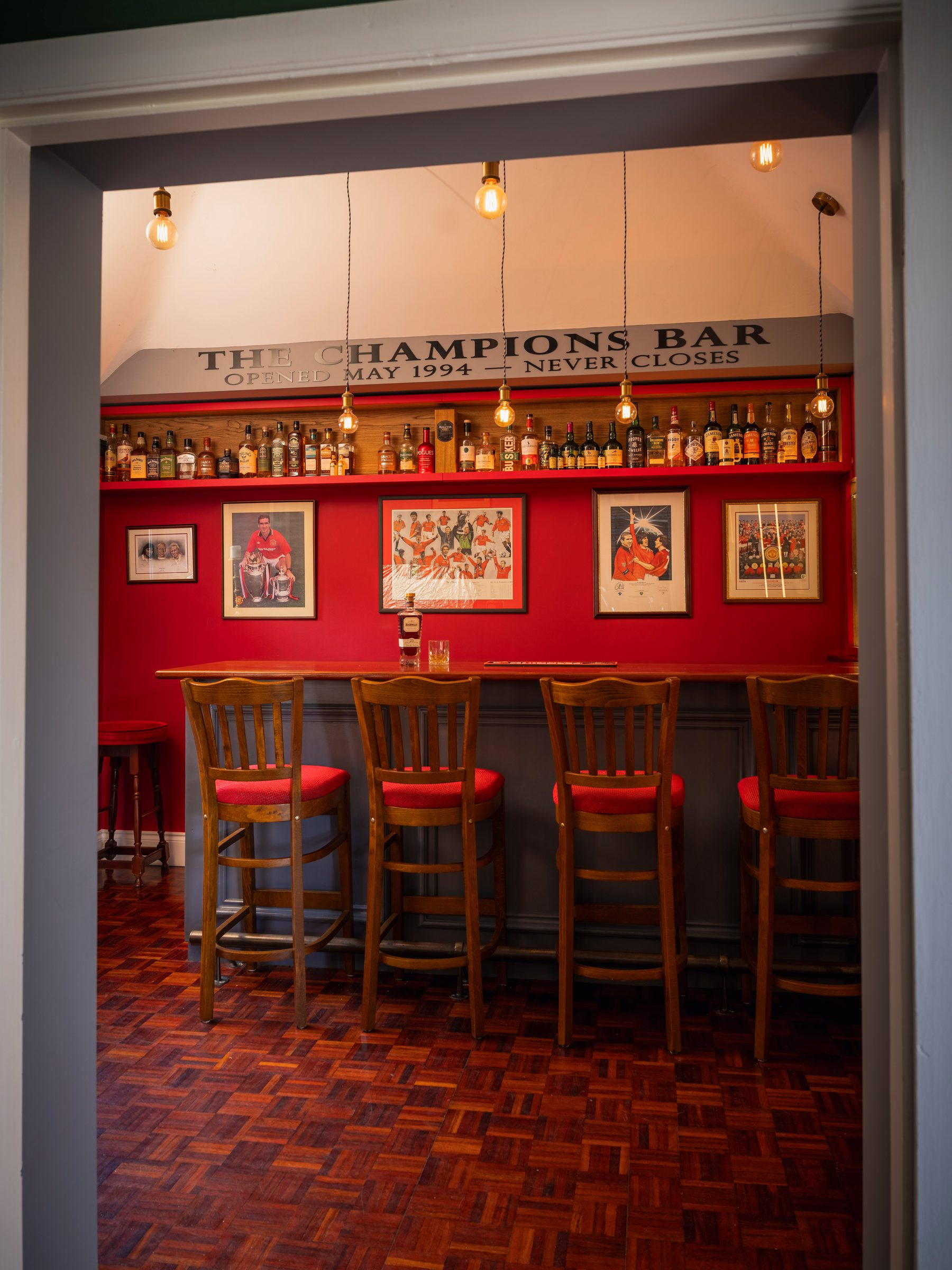 Bespoke home bar viewed through doorway — The Champions Bar, Manchester by Hafferty Interiors