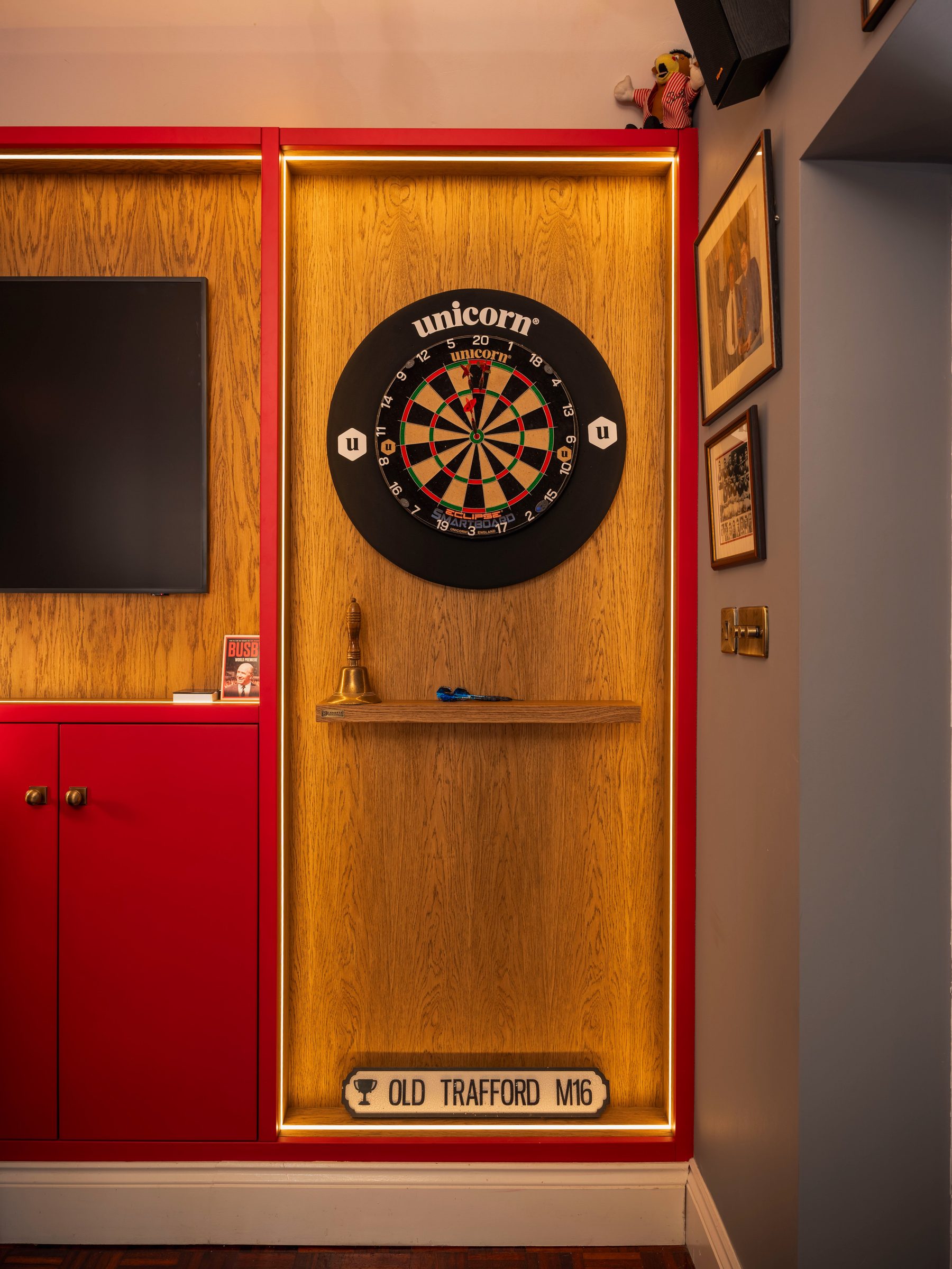Bespoke LED-lit oak dartboard alcove with Old Trafford M16 street sign — The Champions Bar by Hafferty Interiors
