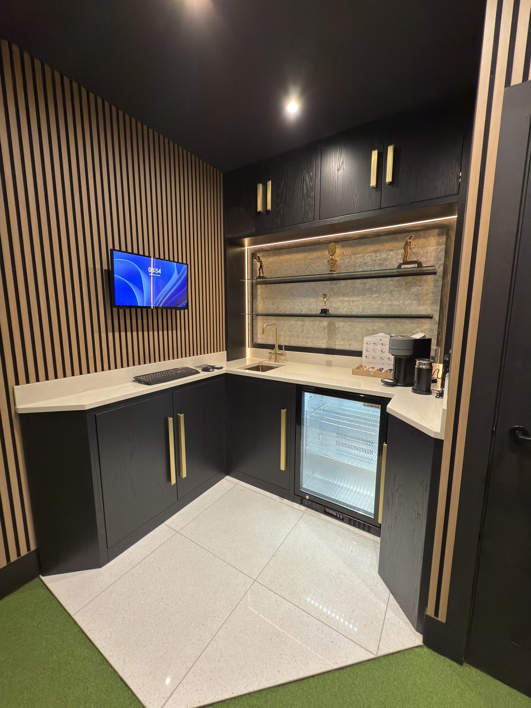 Solid brass handles and creamy satin quartz worktop with Quooker tap — bespoke golf simulator bar Manchester by Hafferty Interiors