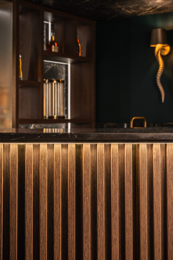Contemporary handleless home bar with back-lit spirit display Worsley — Hafferty Interiors