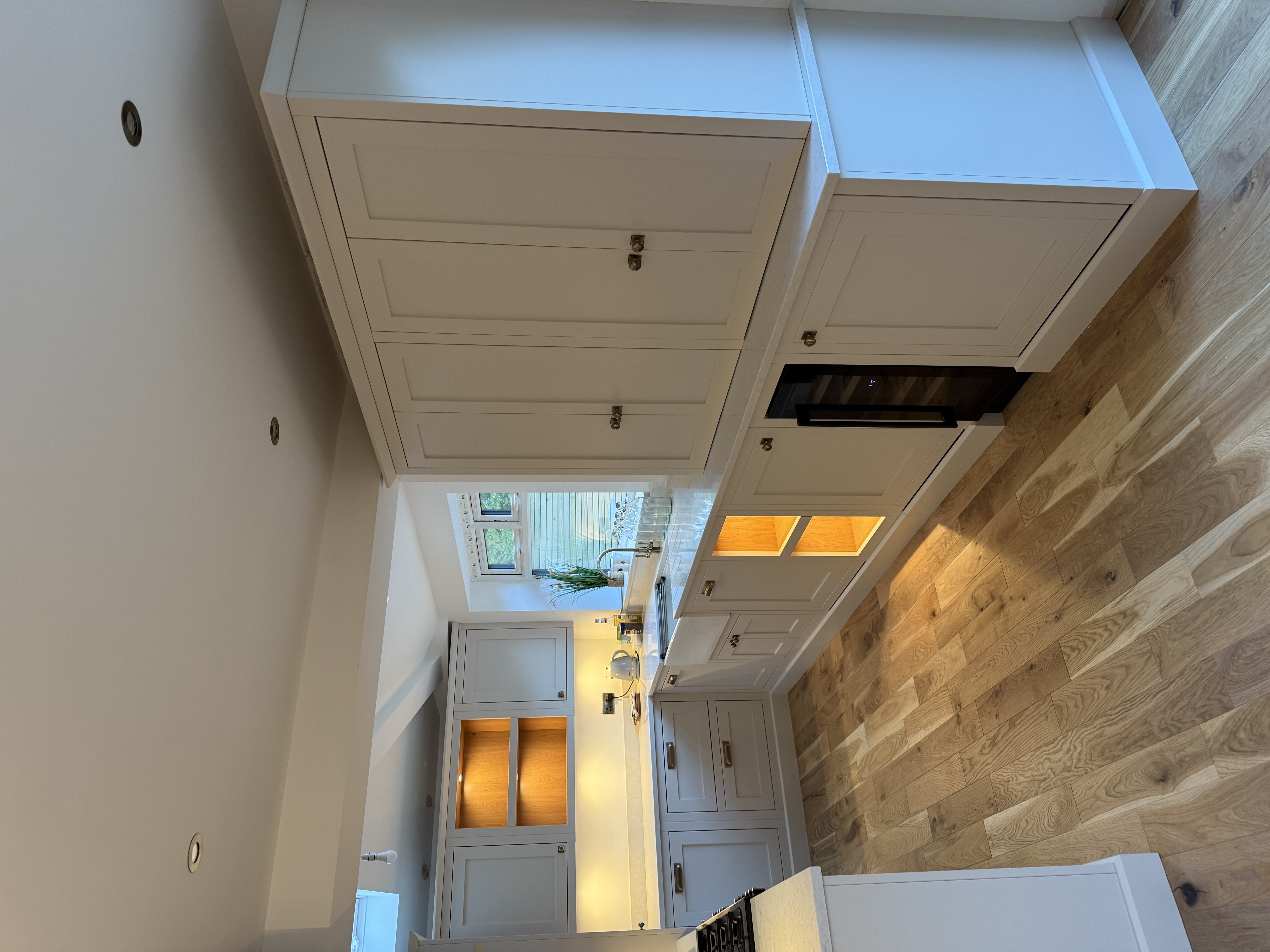 Bespoke in-frame shaker kitchen in Cheadle with putty cabinetry and LED oak niches — Hafferty Interiors