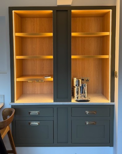 Bespoke in-frame coffee and utility station — deep green painted drawers with warm oak open shelving — Hafferty Interiors