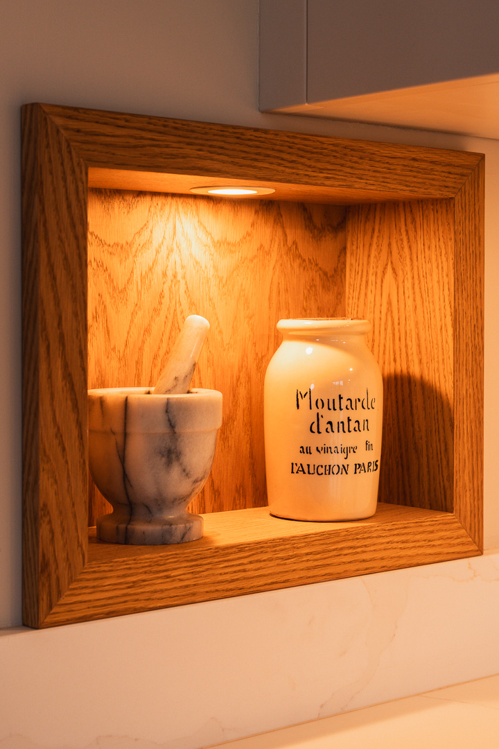 Bespoke oak-framed display niche with integrated spotlight set into worktop run — in-frame kitchen by Hafferty Interiors