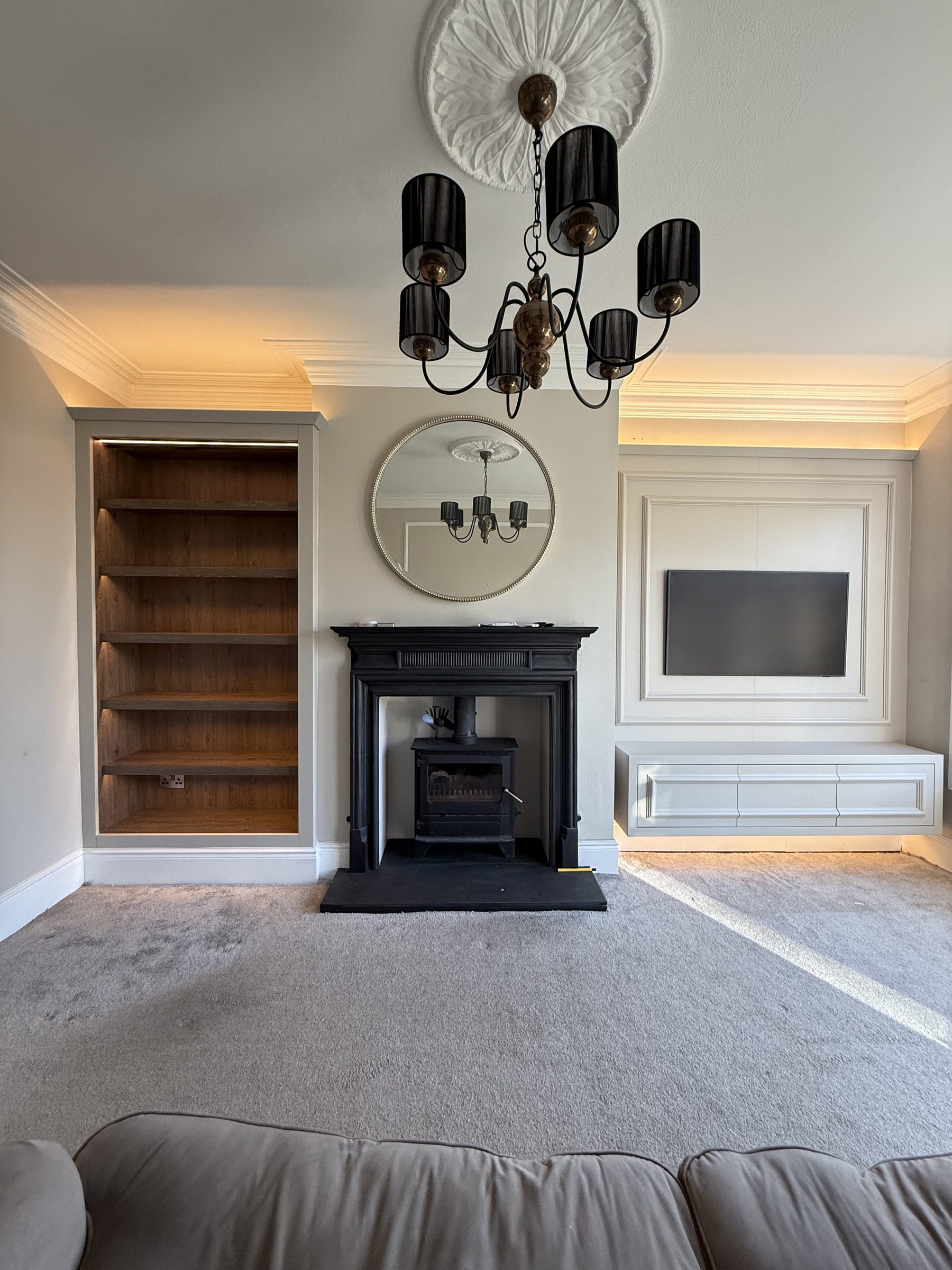 Full period living room with bespoke media wall, oak bookcase and original cast iron fireplace — Hafferty Interiors