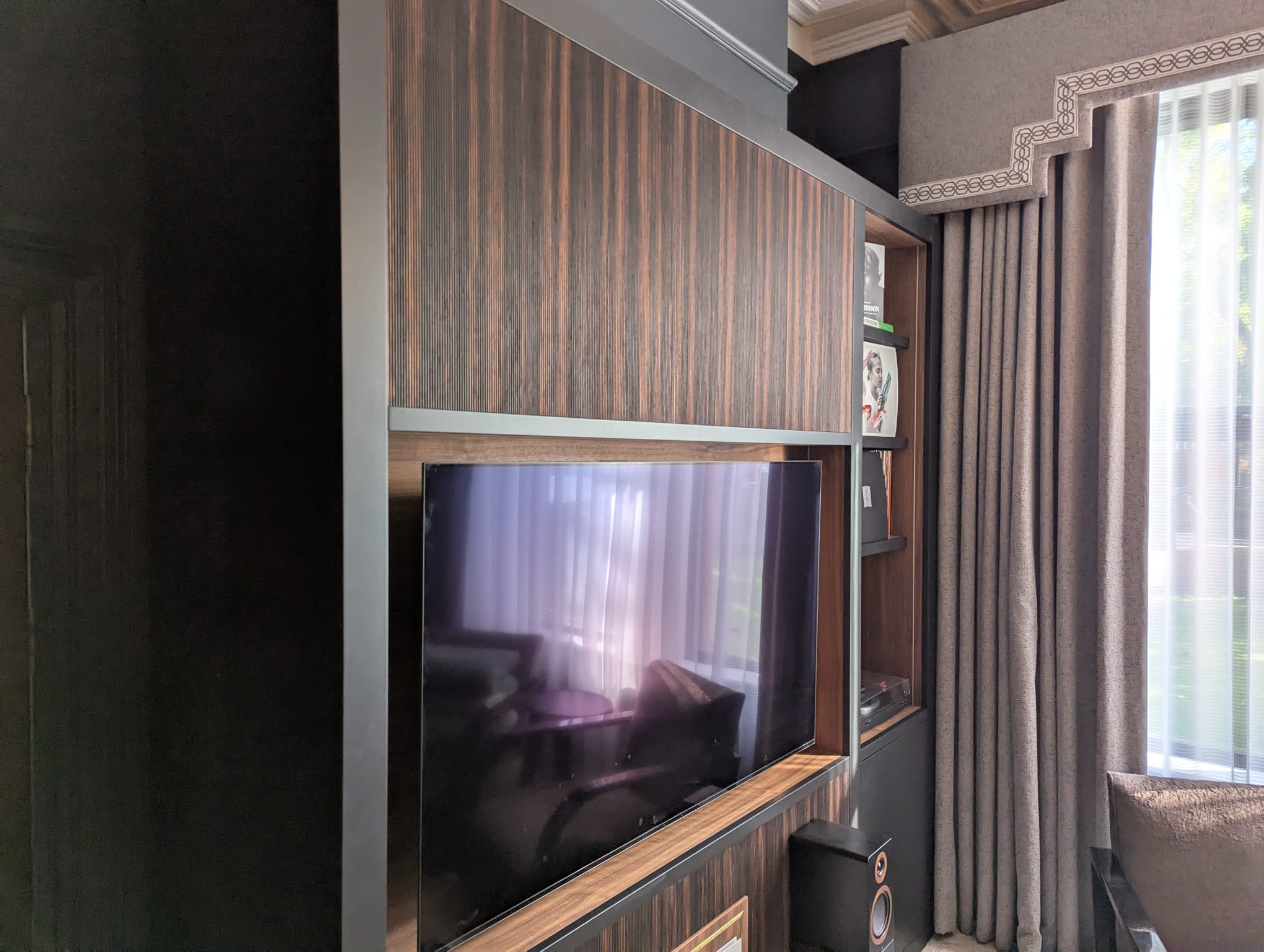 Bespoke ebony veneer media unit with warm walnut TV recess and vinyl display shelving — Hafferty Interiors