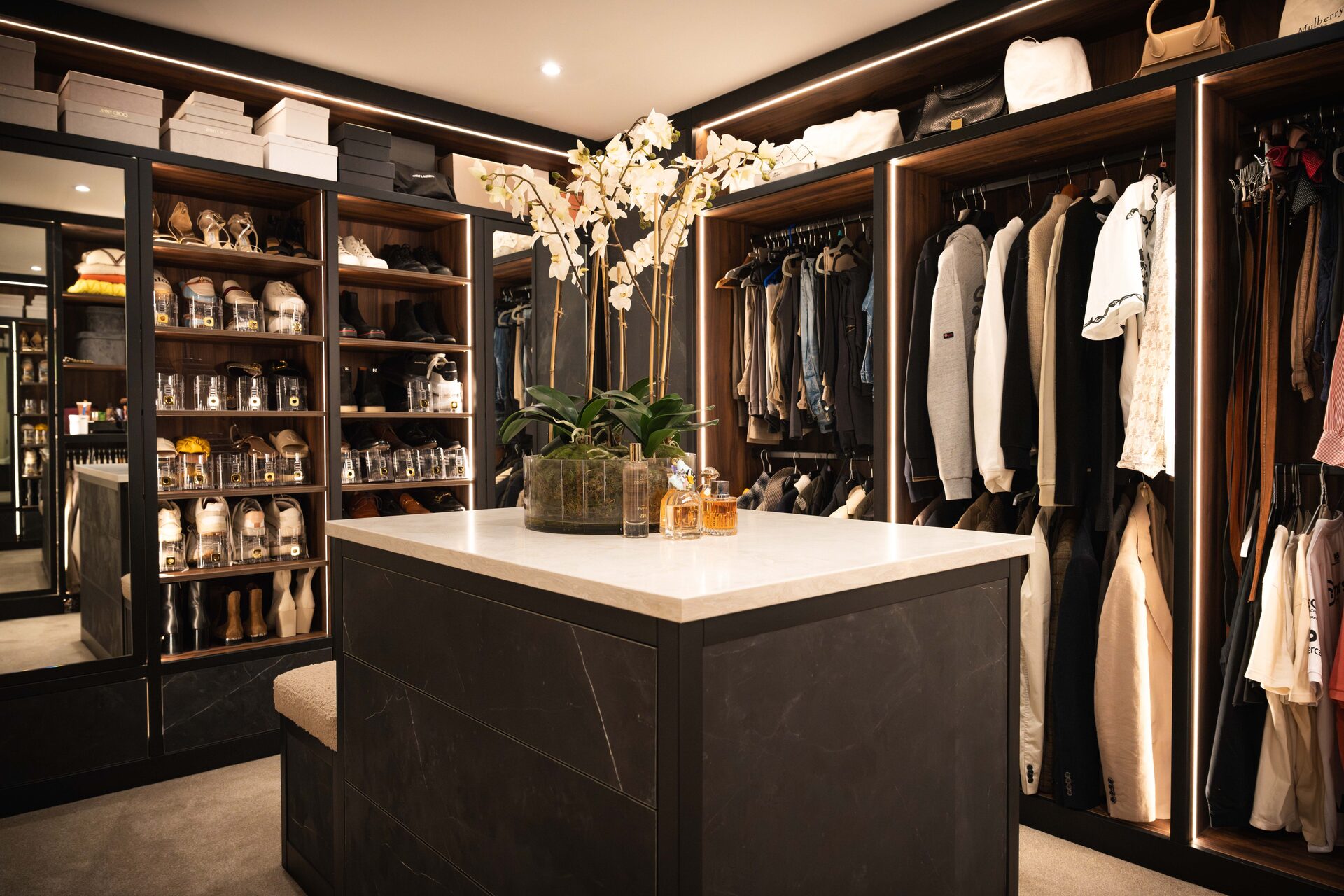 Secret room bespoke walk-in wardrobe Cheshire — walnut and stone island by Hafferty Interiors