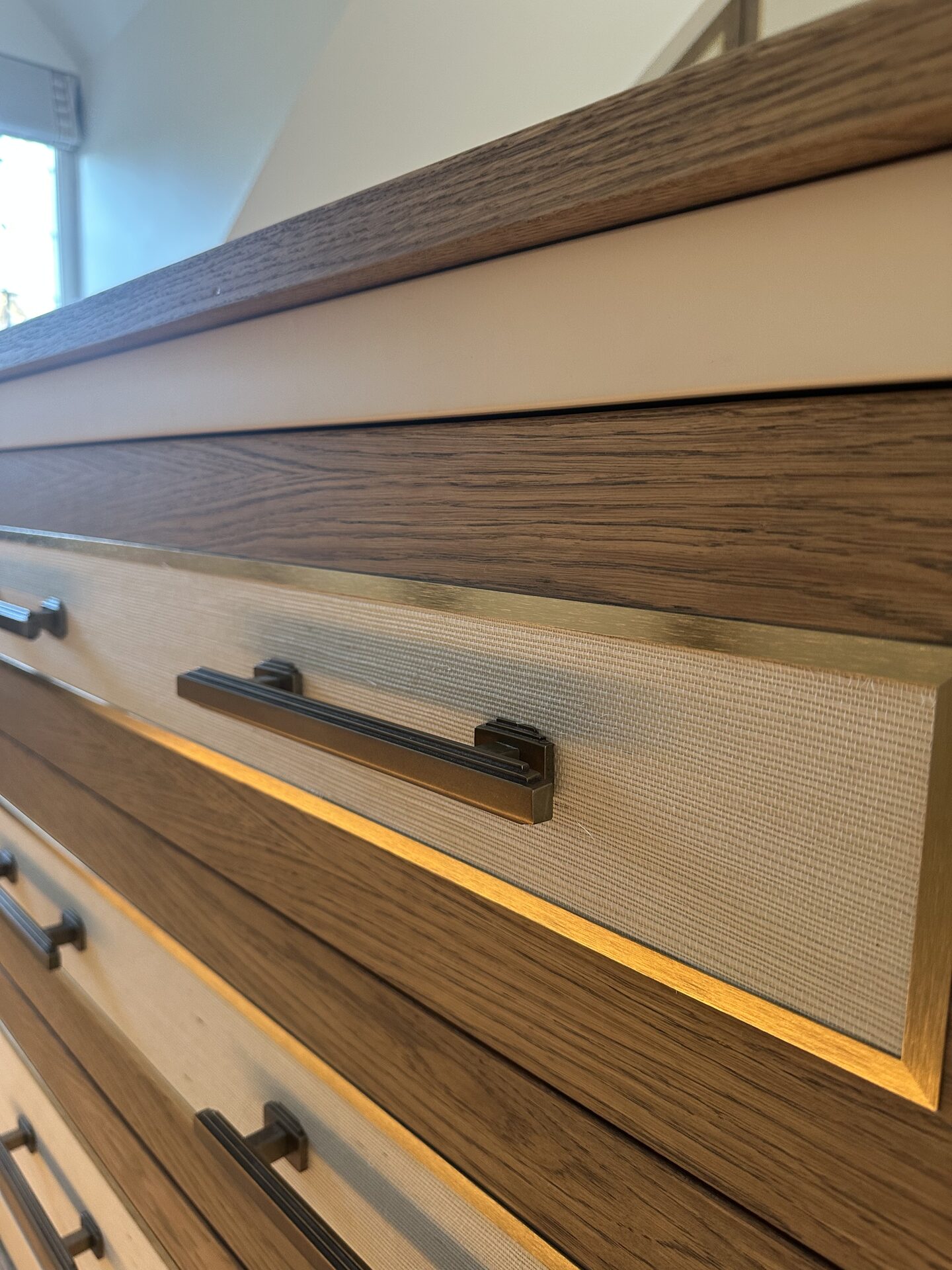 Brass inlay and textured wallpaper door panels — bespoke walk-in wardrobe by Hafferty Interiors Manchester