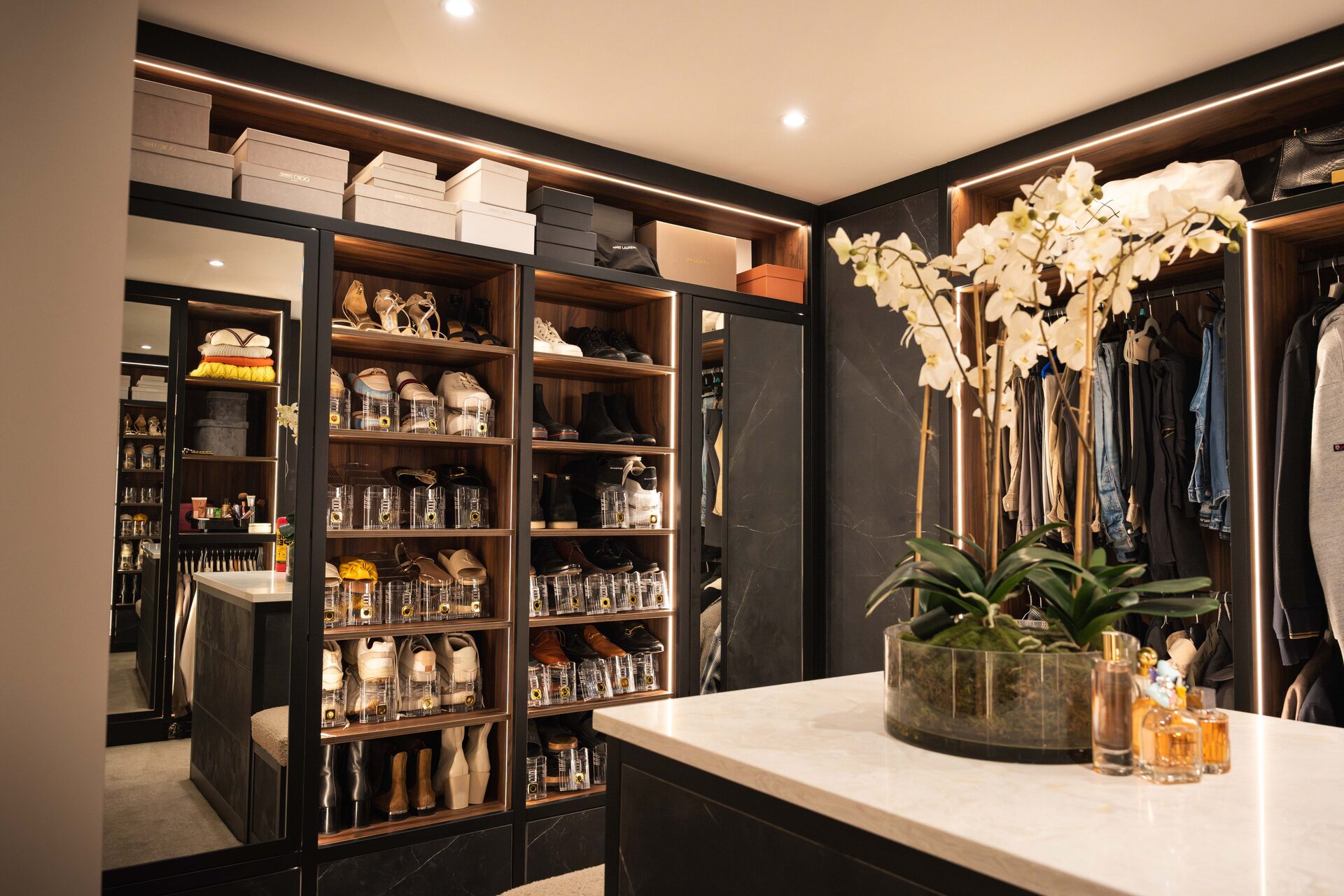 Tailored shoe storage with integrated LED lighting — bespoke walk-in wardrobe by Hafferty Interiors