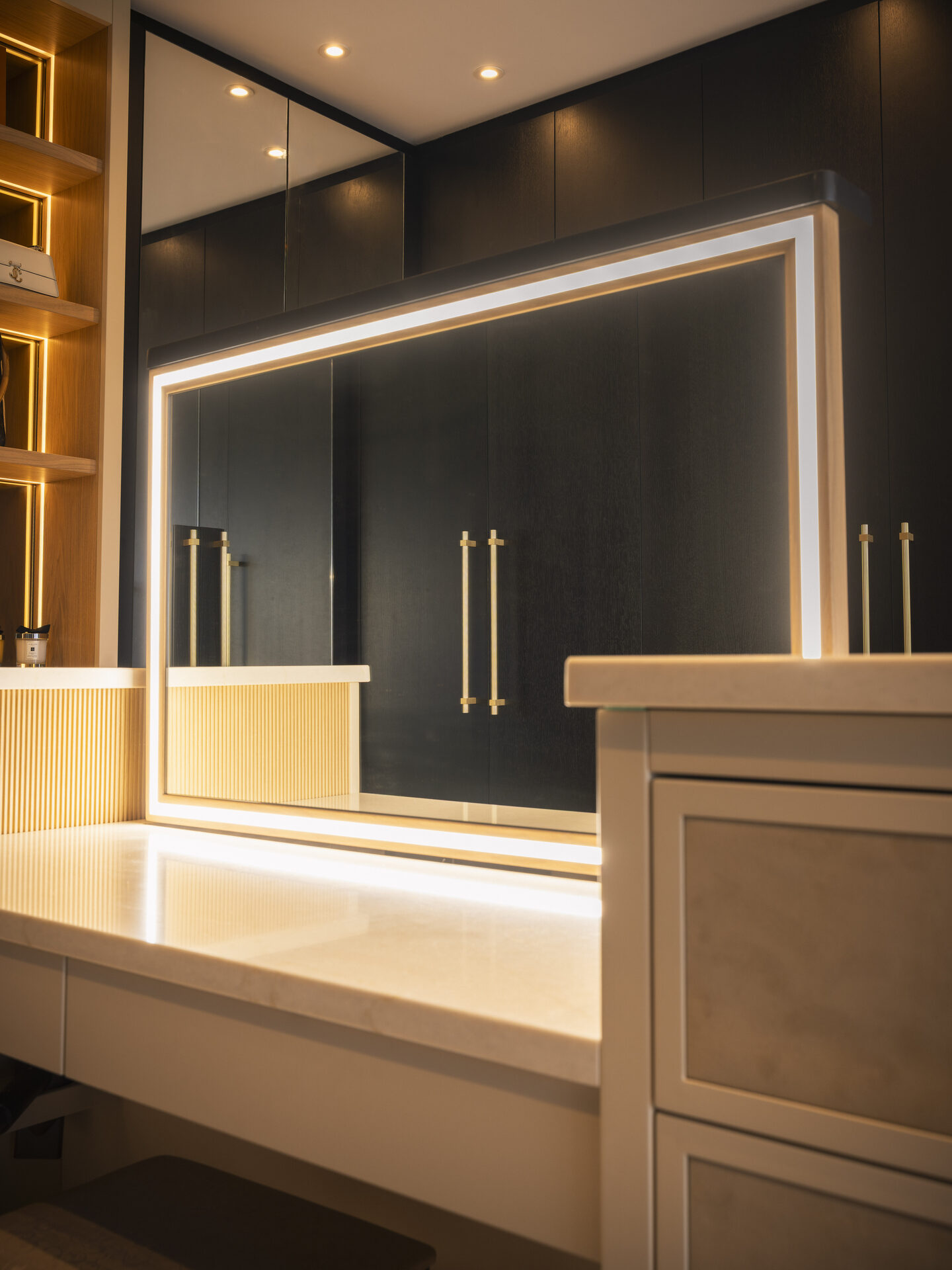 Pop-up LED lit mirror island — bespoke walk-in wardrobe by Hafferty Interiors Manchester