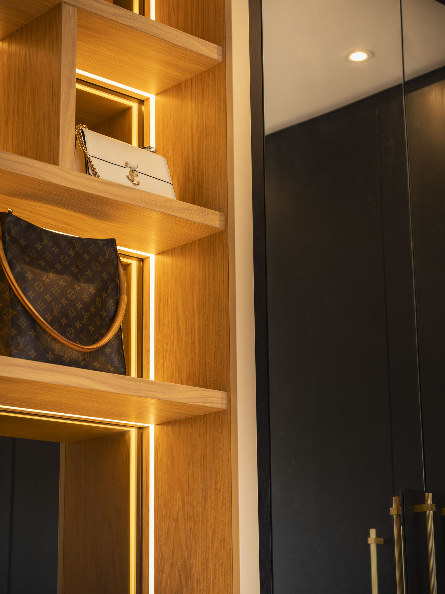 Warm LED mood lighting throughout bespoke walk-in wardrobe — Hafferty Interiors Manchester